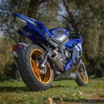 Motocicleta esportiva azul estacionada ao ar livre em um dia ensolarado.