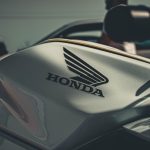 Detalhe do tanque e do logotipo Honda em uma motocicleta, em ambiente externo de iluminação suave