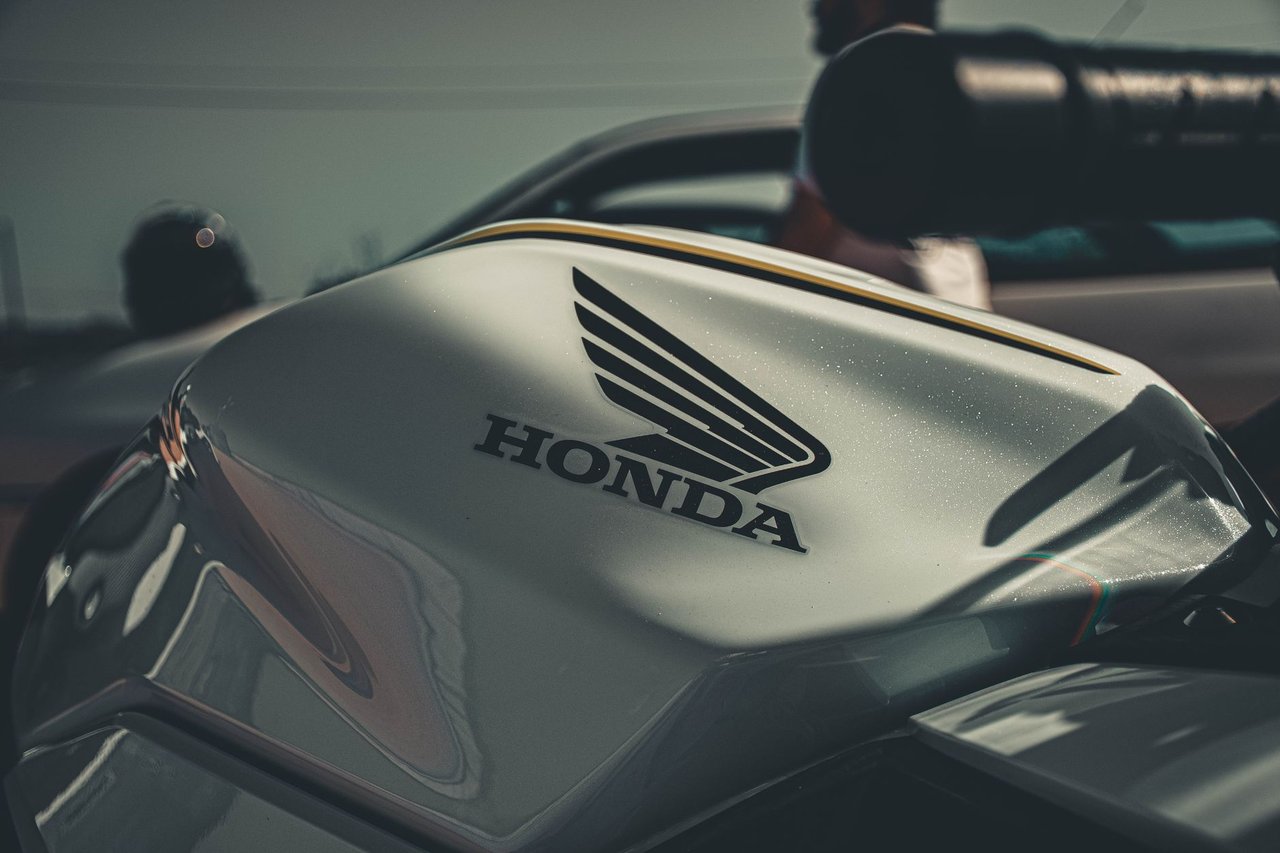 Detalhe do tanque e do logotipo Honda em uma motocicleta, em ambiente externo de iluminação suave